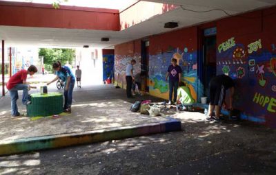 Young people work to paint walls