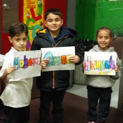 Three children holding art work