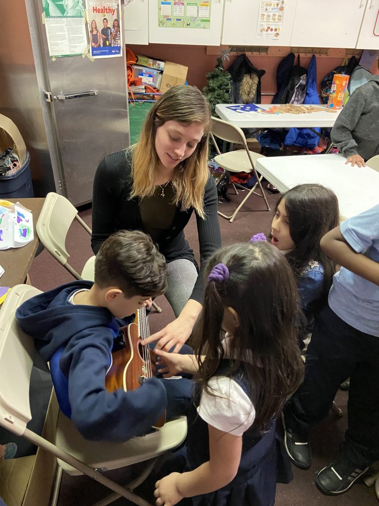 Mohammad, Sajah, and Pippa learning new chords on the ukulele at Towey Recreation Center.