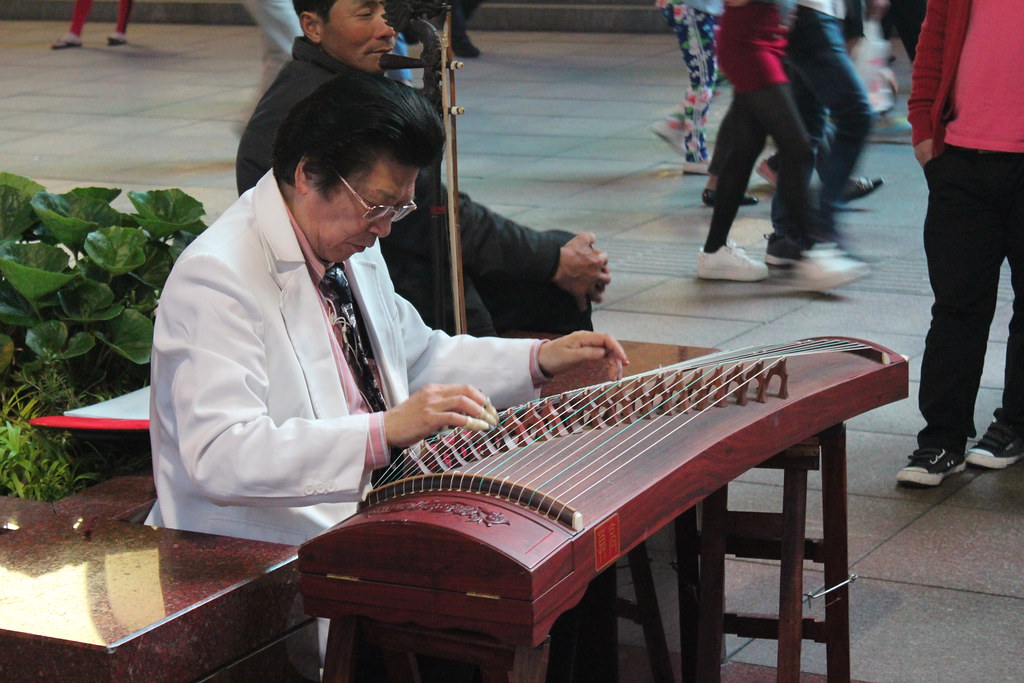 Street Performer Plays a Guzheng(?) by Tim Sheerman-Chase, CC BY 2.0, via Flickr