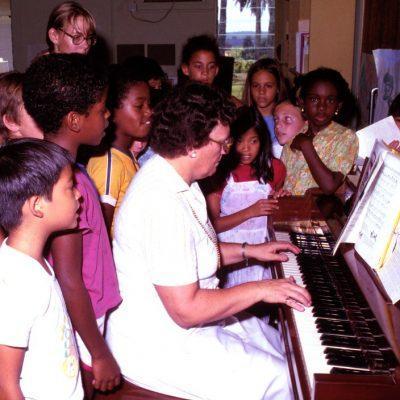 Children being taught the to play the piano