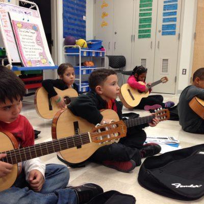 Children learning to play the guitar