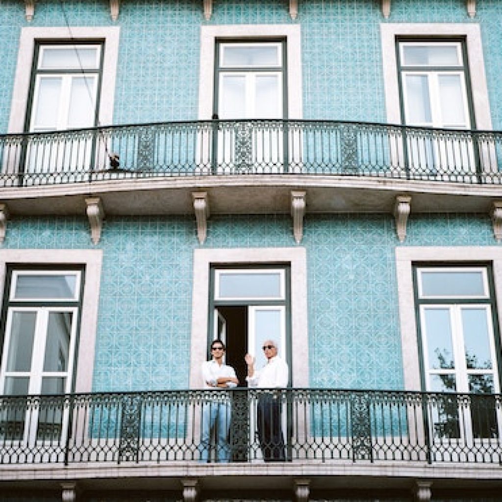 Teal colored home with small balconies.