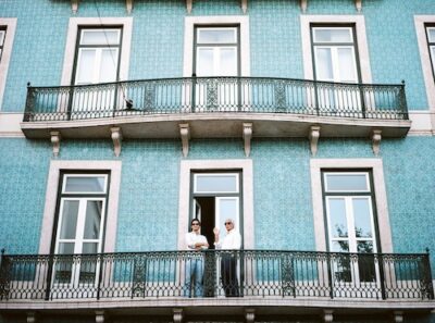 Teal colored home with small balconies.