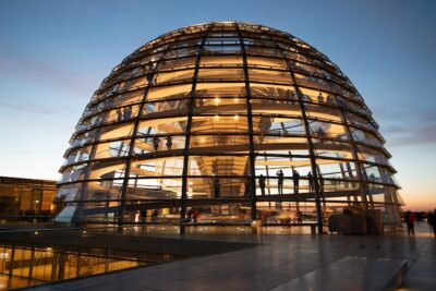 Large dome lit up with yellow lights during a sunset.