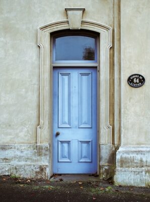 Light blue colored front door with molding all around.