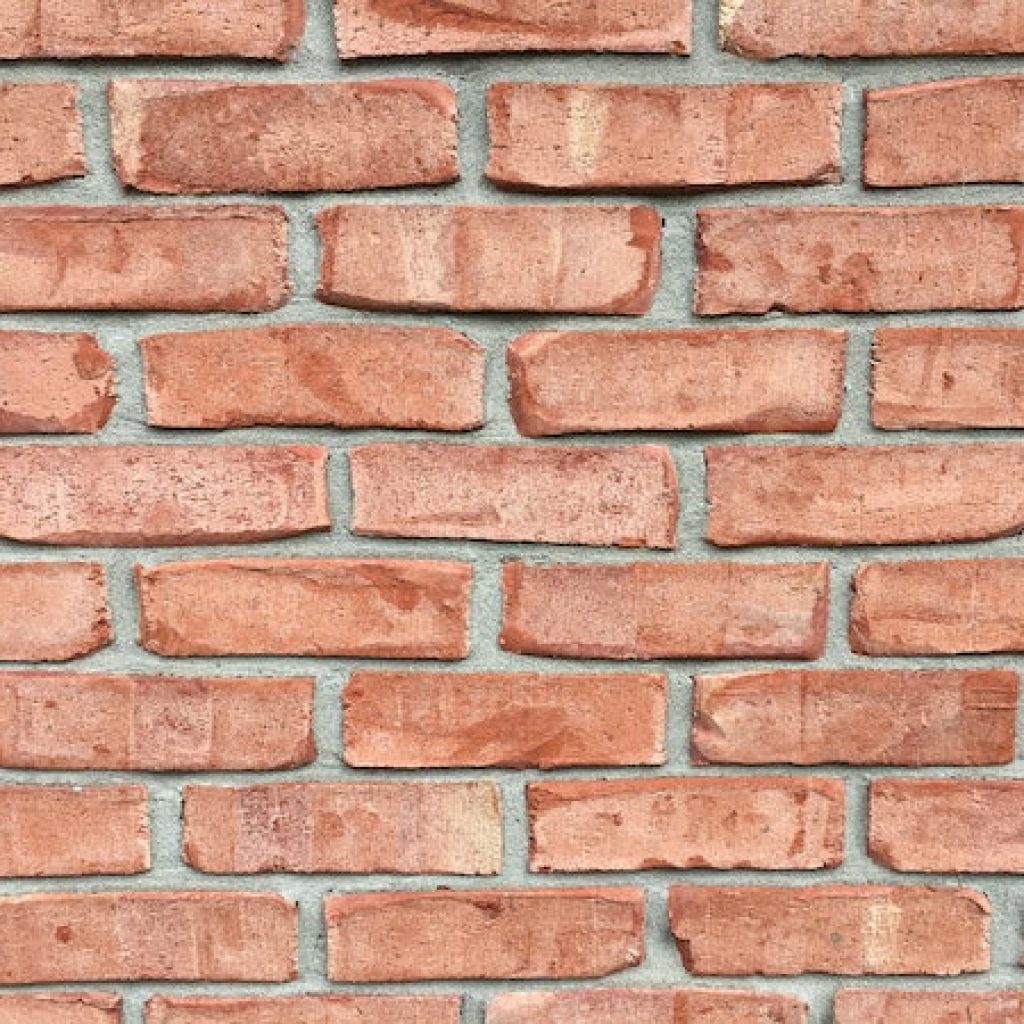 Bricks piled on top of one another with gray cement in between