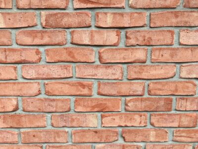 Bricks piled on top of one another with gray cement in between