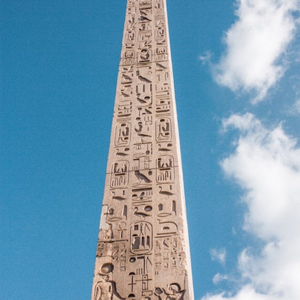 Tall stone obalisk with ancient writing from the bottom to the top