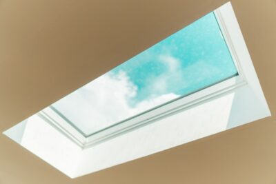 Skylight facing a cloud in the blue sky with white ceiling