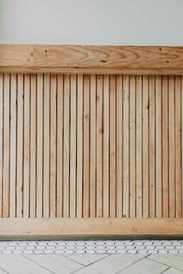 Wood paneling on a light stoned color wall with white tile floor