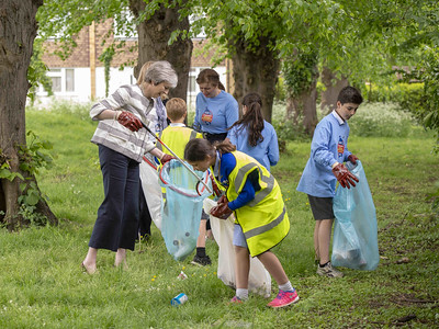 Children and woman cleaning up garbage